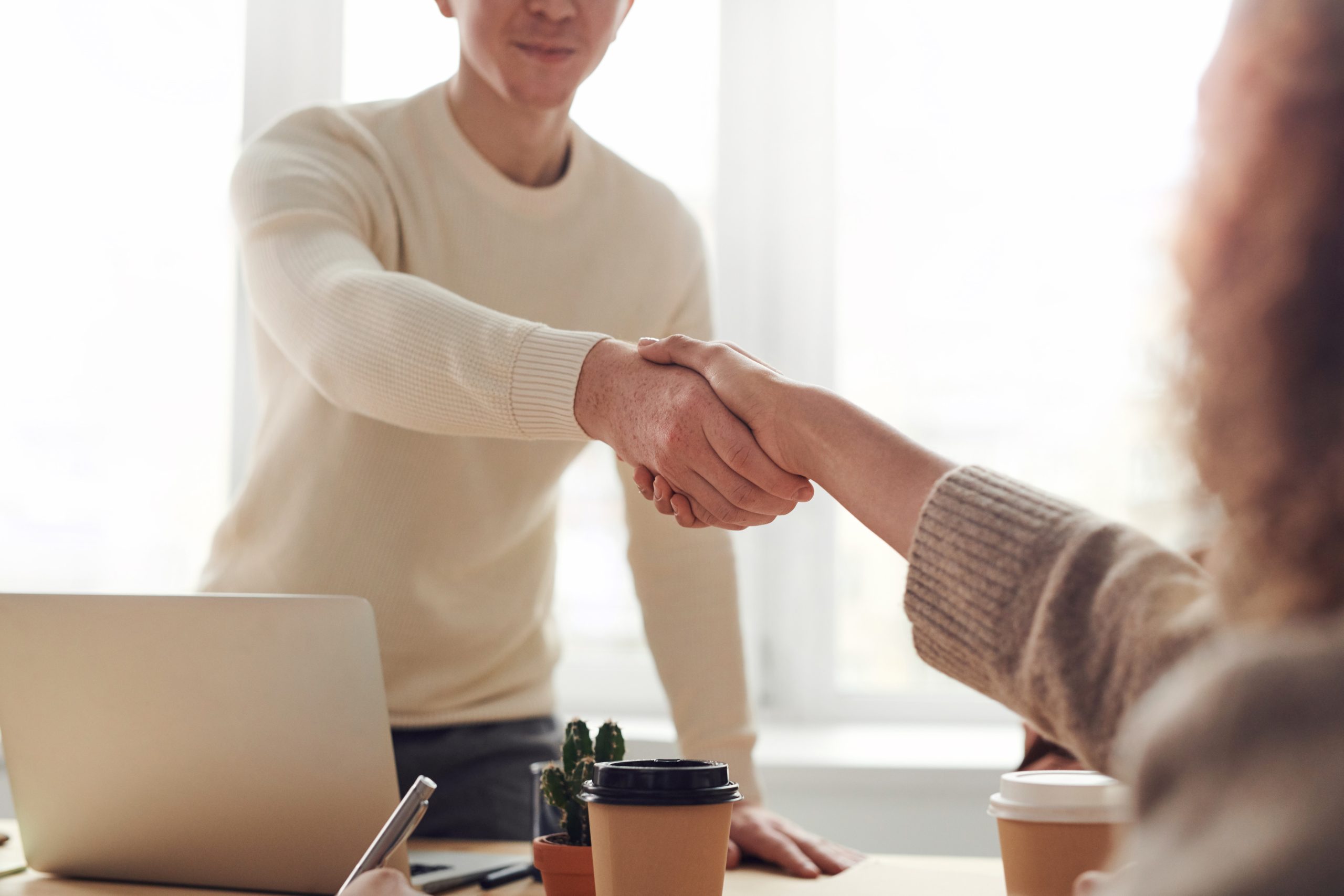 People shaking hands to show how you can do business outsourcing ti benefit your business