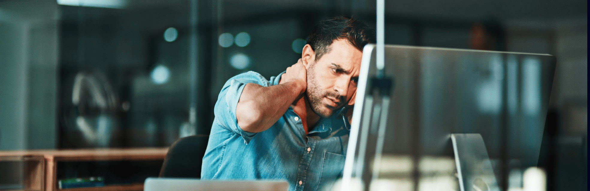 man sitting in an office using is computer to represent the most common mistakes when submitting expenses